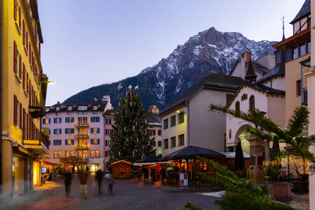 Abendansicht der Brig-Glis-Strasse mit Weihnachtsbaum vor dem Hintergrund der Alpengipfel